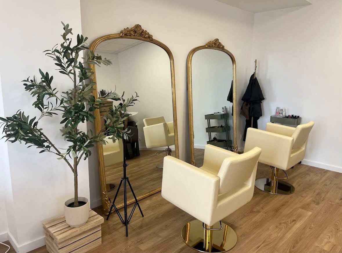 Espace coiffure : grands miroirs dorés en arche et fauteuils crème